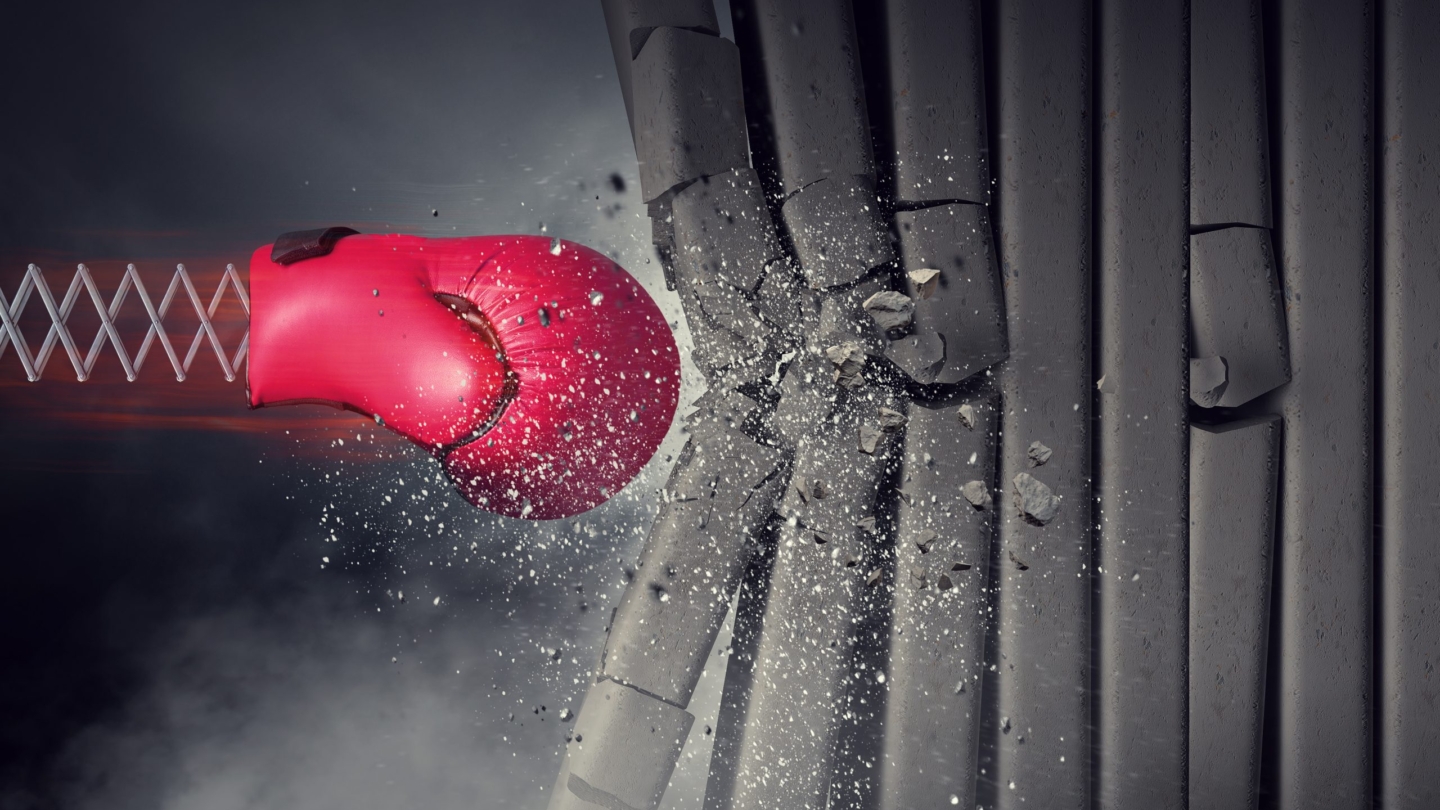 Red boxing glove on spring breaking concrete wall. Mixed media