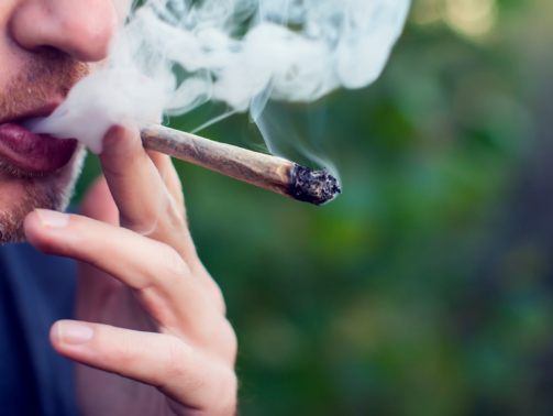Man smokes a joint. Medical marijuana use and legalization of the cannabis, light drugs concept